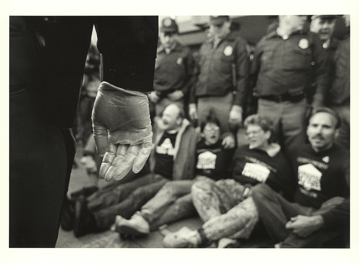 Ben Thornberry's photo of a police person wearing rubber gloves at an ACT UP demonstration in 1988