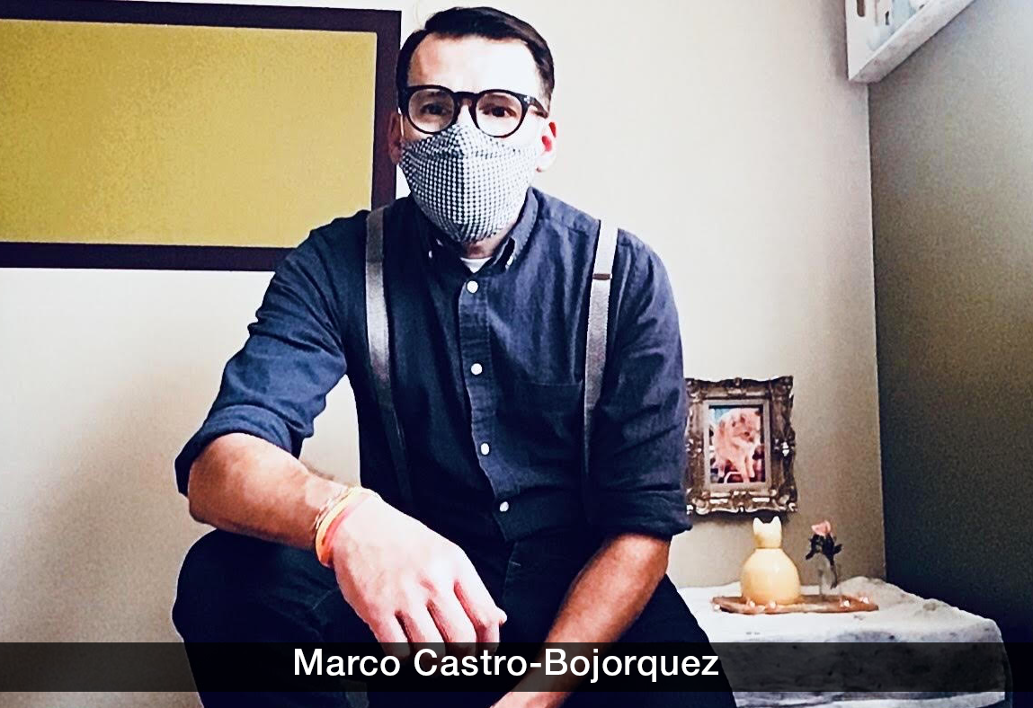 photo of marco castro-bojorquez: he's seated, wearing a mask, blue shirt and pants with suspenders, and looking at the camera
