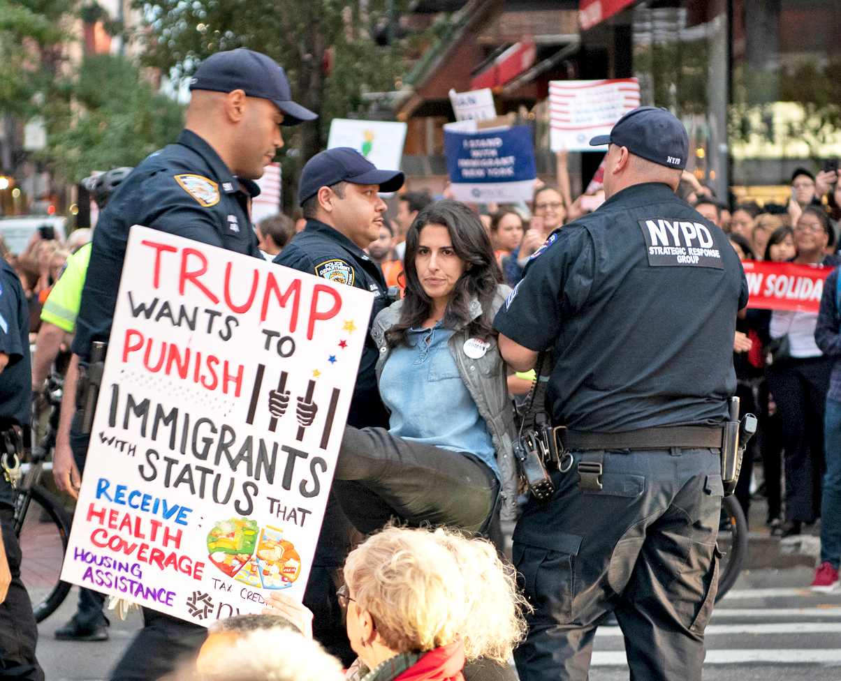 photo of erica lessem being arrested for civil disobedience at a public charge rally in 2019