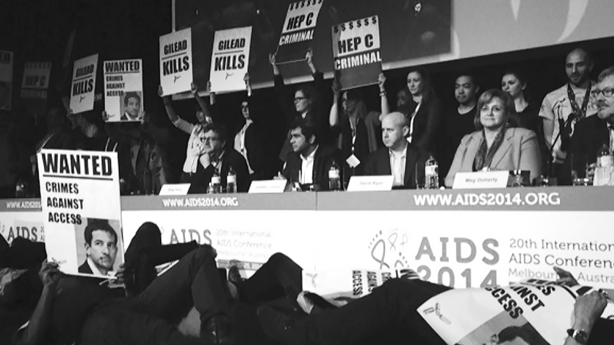 Black and white photo of people obviously protesting (holding signs) at the International AIDS Conference in 2014