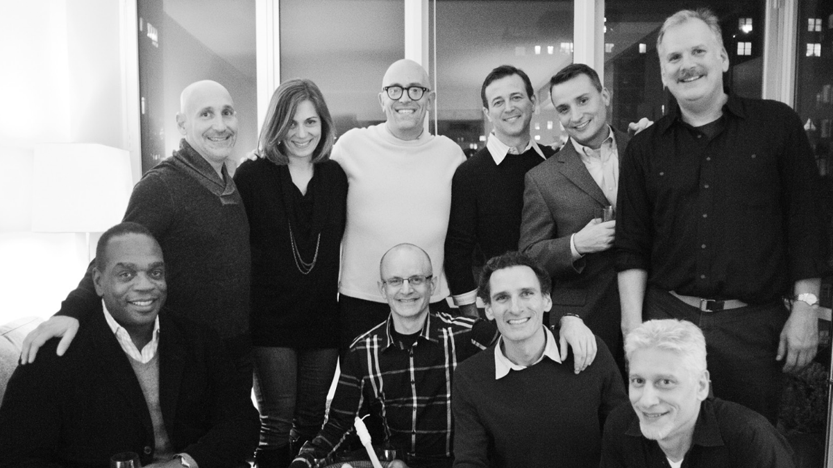 Group of 10 people smiling at the camera; they appear to know each other well and are enjoying each others company