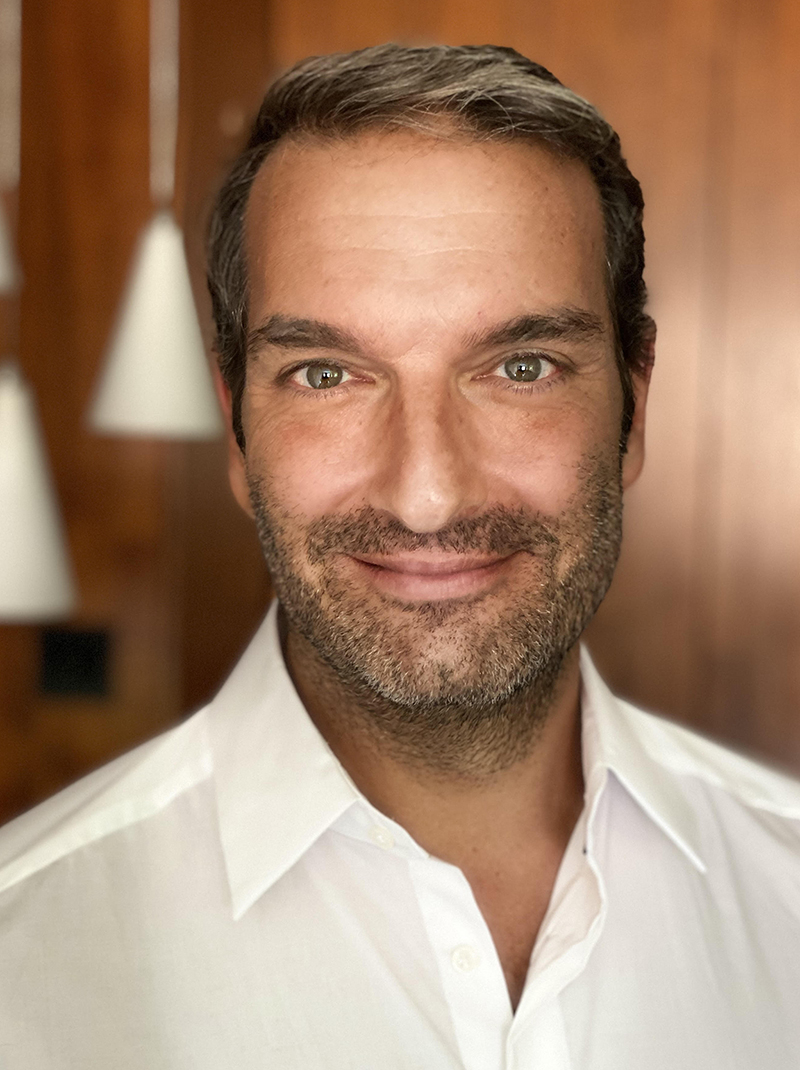 White male with beard looking straight into the camera; wearing a white dress shirt