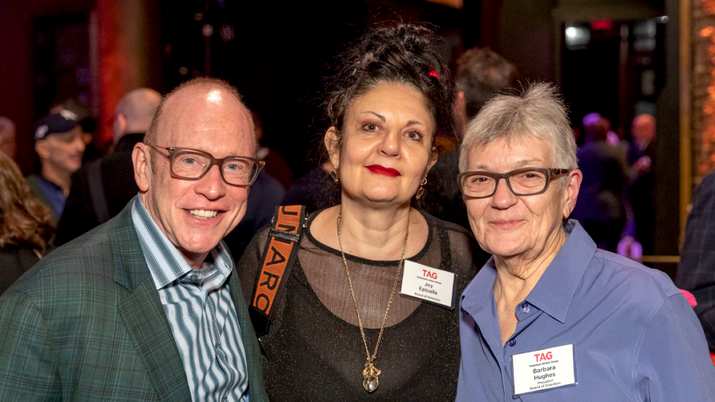 One Older White Man With Glasses And Two Older White Woman Looking At Camera. Name Tags On Women Read "Joy Episalla" And "Barbara Hughes"
