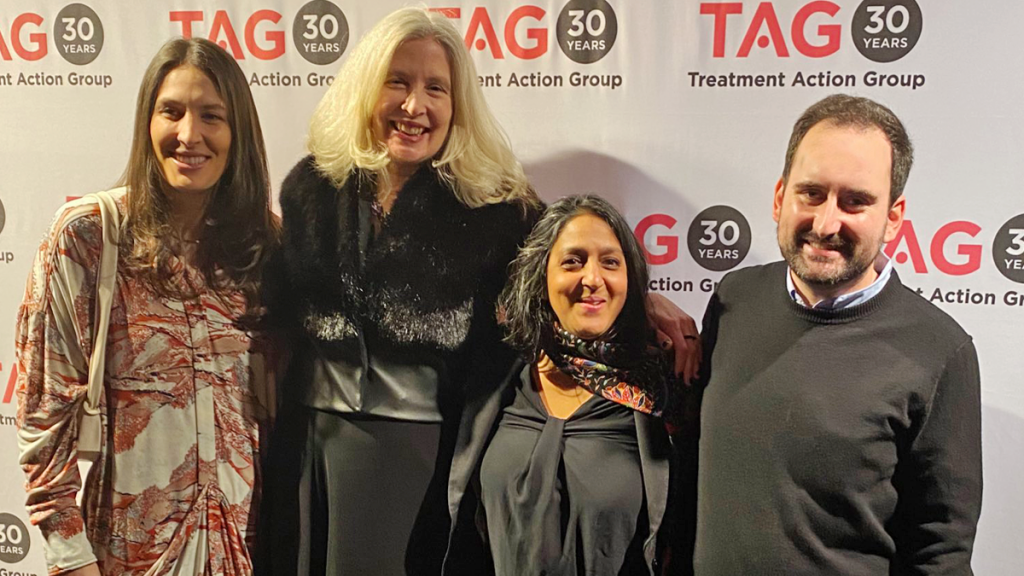 Three Women And One Man In Front Of TAG's Step And Repeat Backdrop