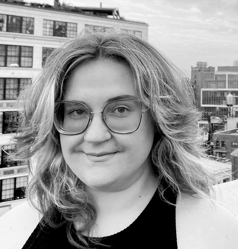 Photo of blond woman with glasses smiling with New York City in the background