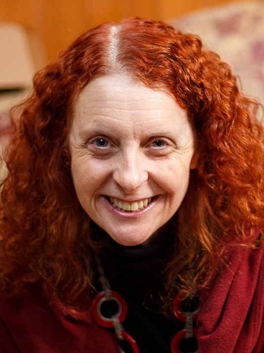 headshot of Dr. Jennifer Furin, caucasian woman with red hair wearing a dark red shirt