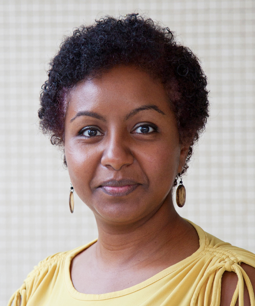 picture of dr. sara suliman: person of color, smiling, wearing a yellow blouse