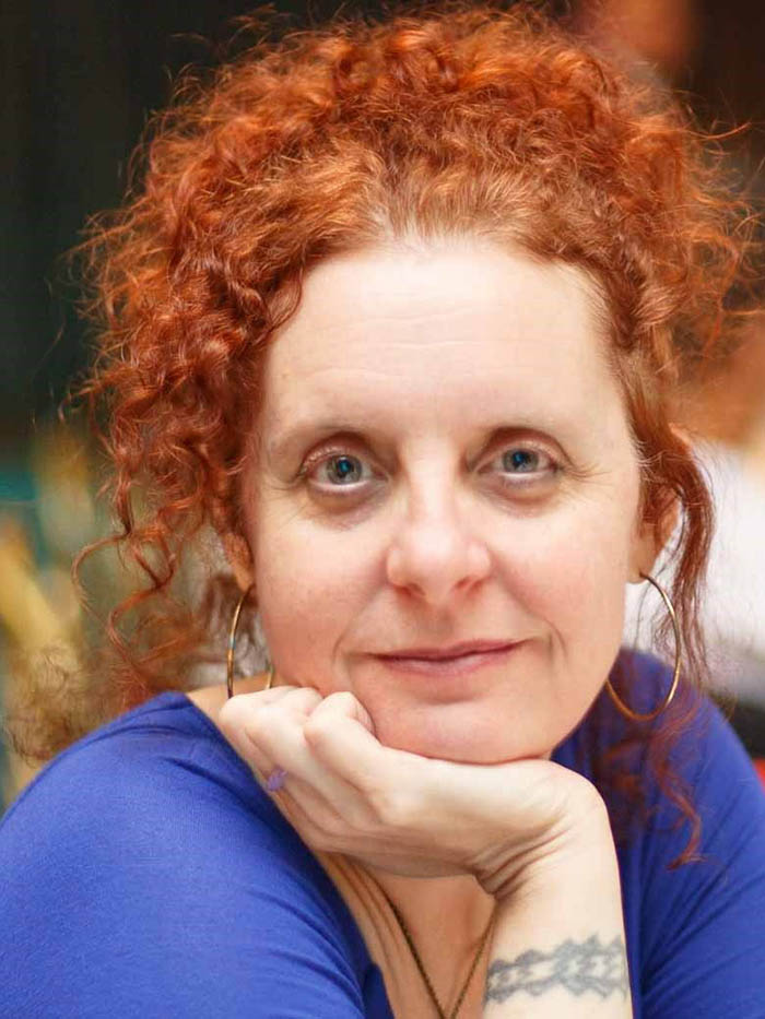 Photo of Dr. Jennifer Furin; white woman with red hair and light eyes, looking at the camera. Blue shirt.