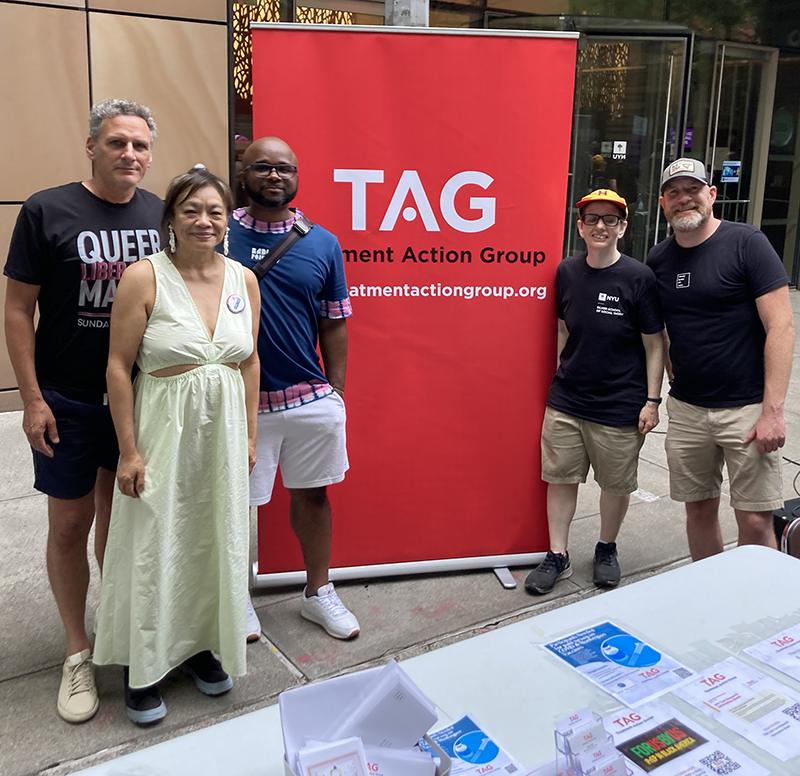 members of TAG's staff and board smiling and standing next to a TAG sign